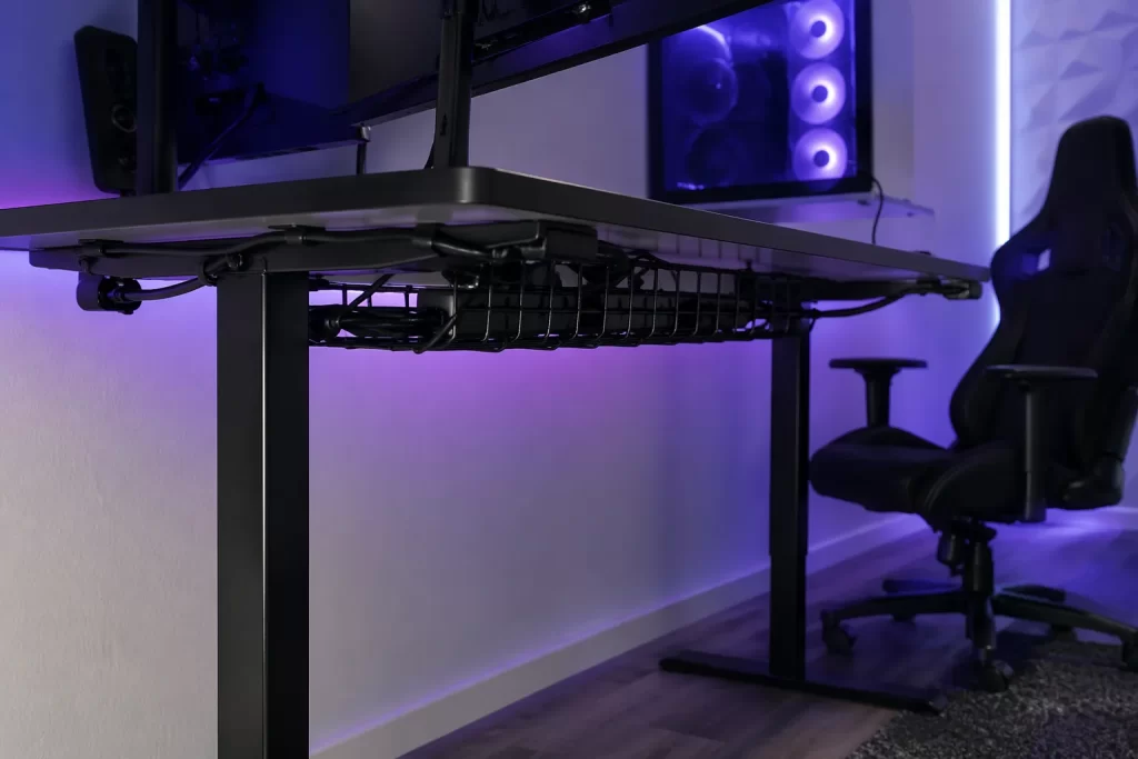 Strakke gaming setup met kabelgoot onder het bureau voor nette, weggewerkte kabels.
